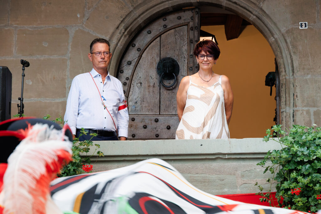 Homme et femme devant une porte ancienne en arche de pierre