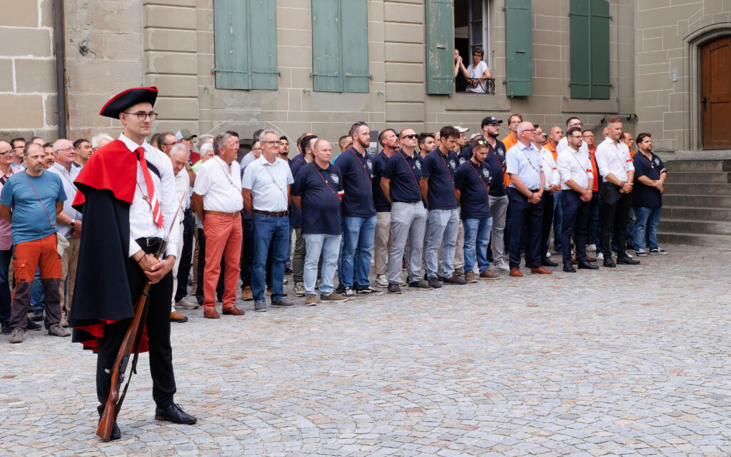 Garde en costume traditionnel suisse devant une foule rassemblée