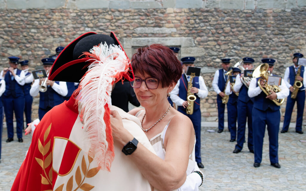 Femme embrassant un personnage costumé devant une fanfare