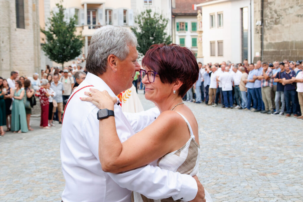 Couple dansant sur une place publique devant une foule