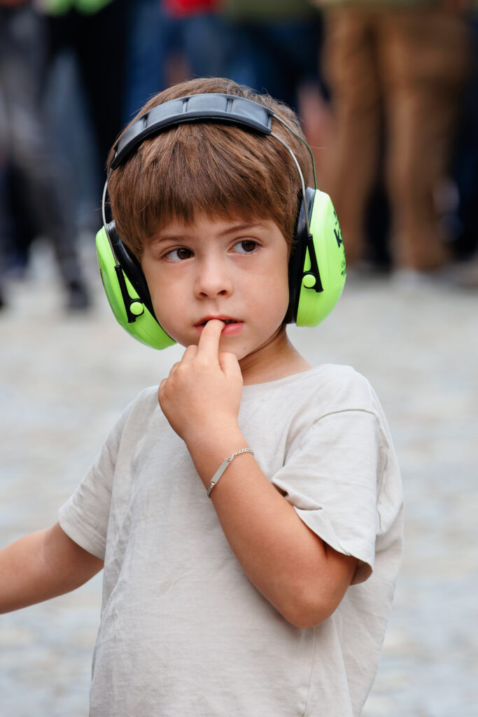 Enfant pensif portant un casque antibruit vert fluo