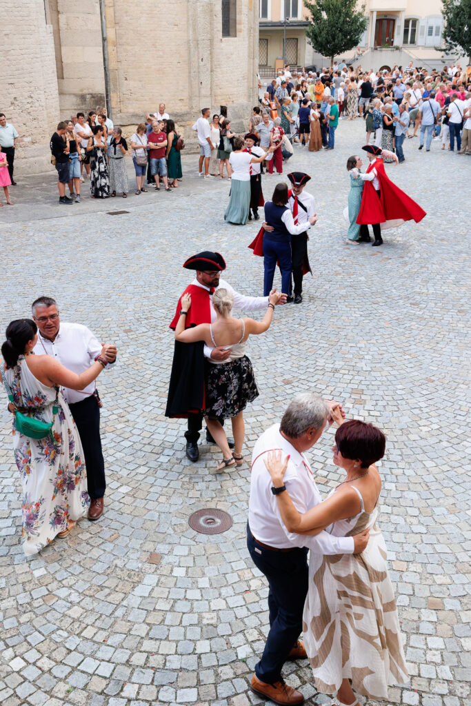 Danse folklorique en costumes traditionnels sur une place pavée