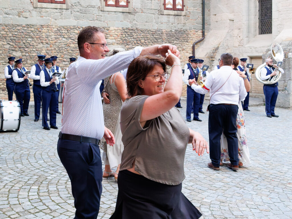 Couple dansant joyeusement devant une fanfare en plein air