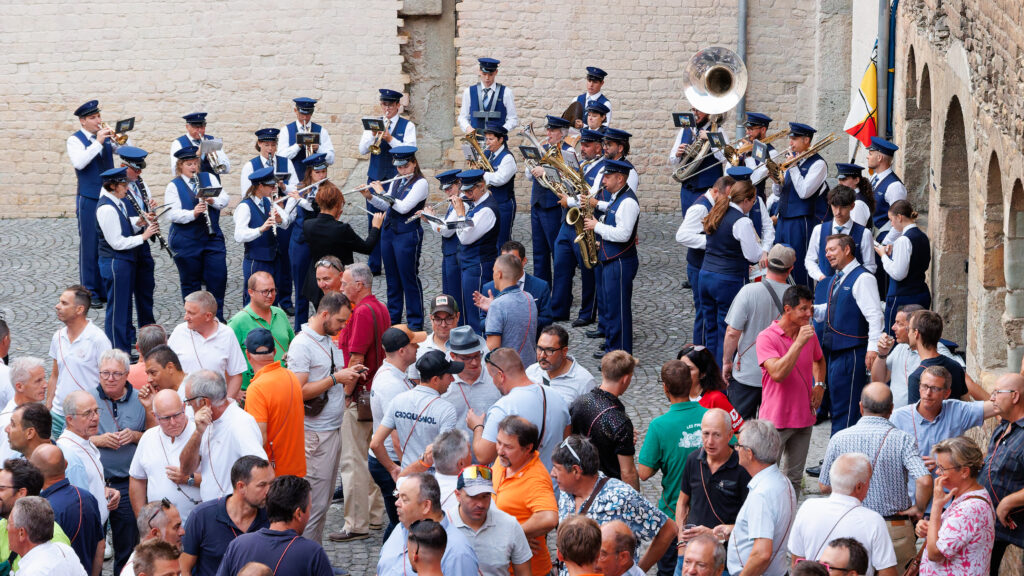 Fanfare en uniforme bleu jouant devant une foule en plein air