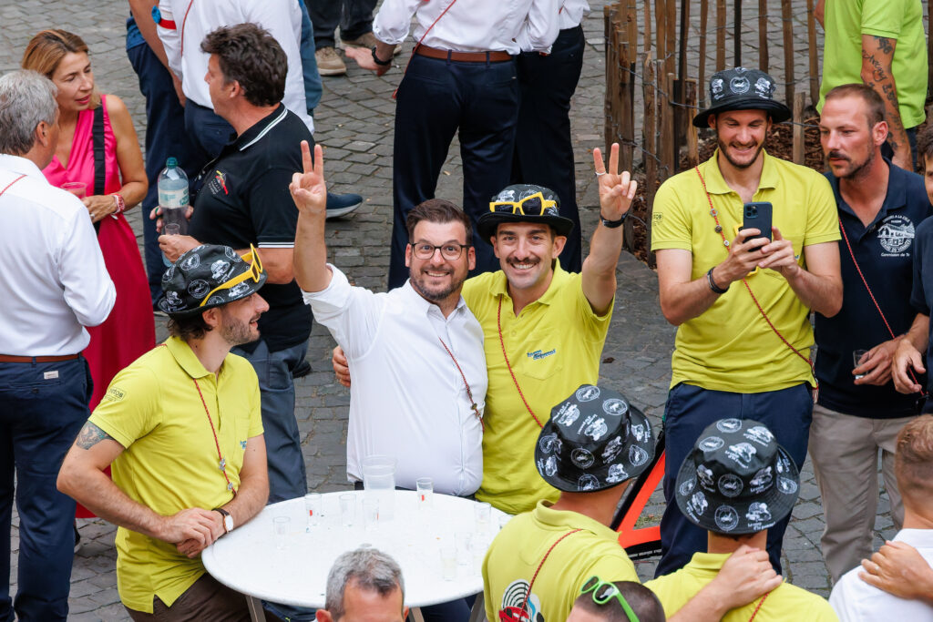 Groupe festif en polos jaunes posant avec signe victoire