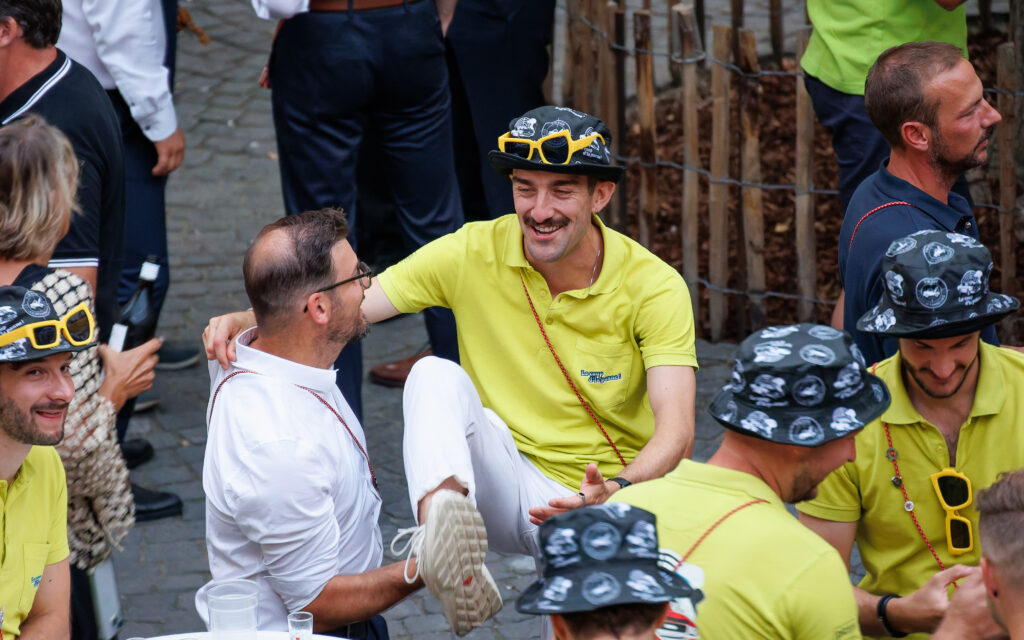 Groupe d'hommes joyeux en polos jaunes lors d'un événement festif