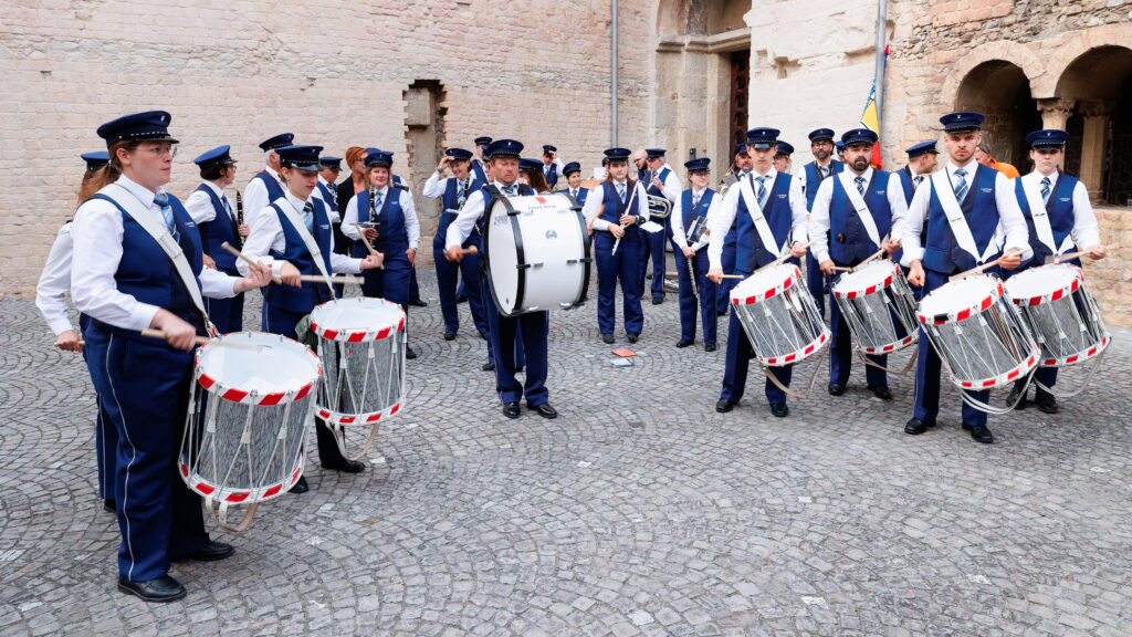 Fanfare en uniforme bleu jouant des tambours en place pavée