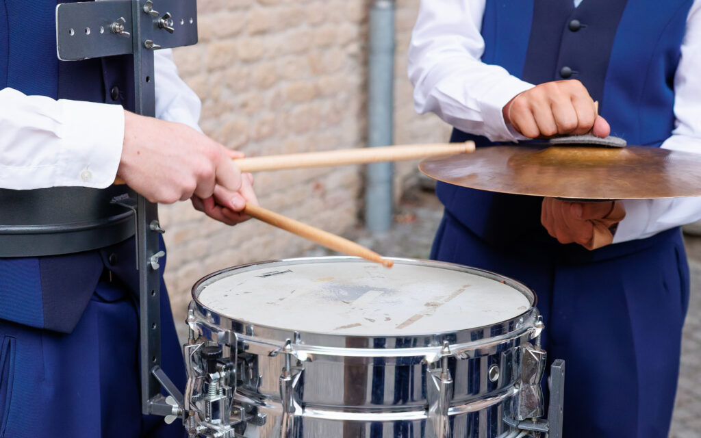 Musiciens en costume bleu jouant caisse claire et cymbale