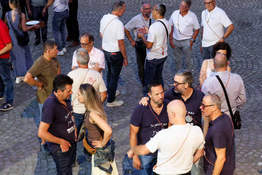 Groupe de personnes discutant sur une place pavée en été