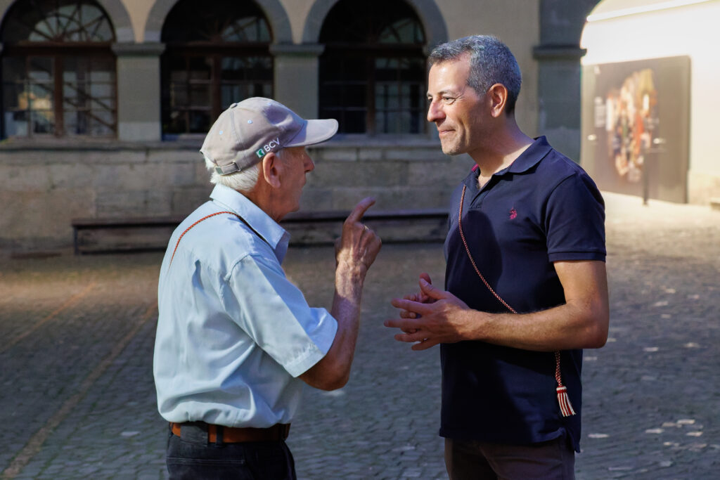 Deux hommes en conversation sur une place publique ensoleillée