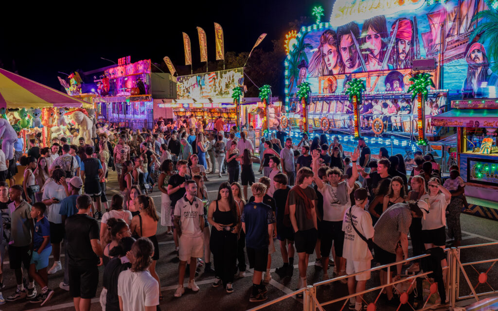 Foule animée dans une fête foraine colorée la nuit