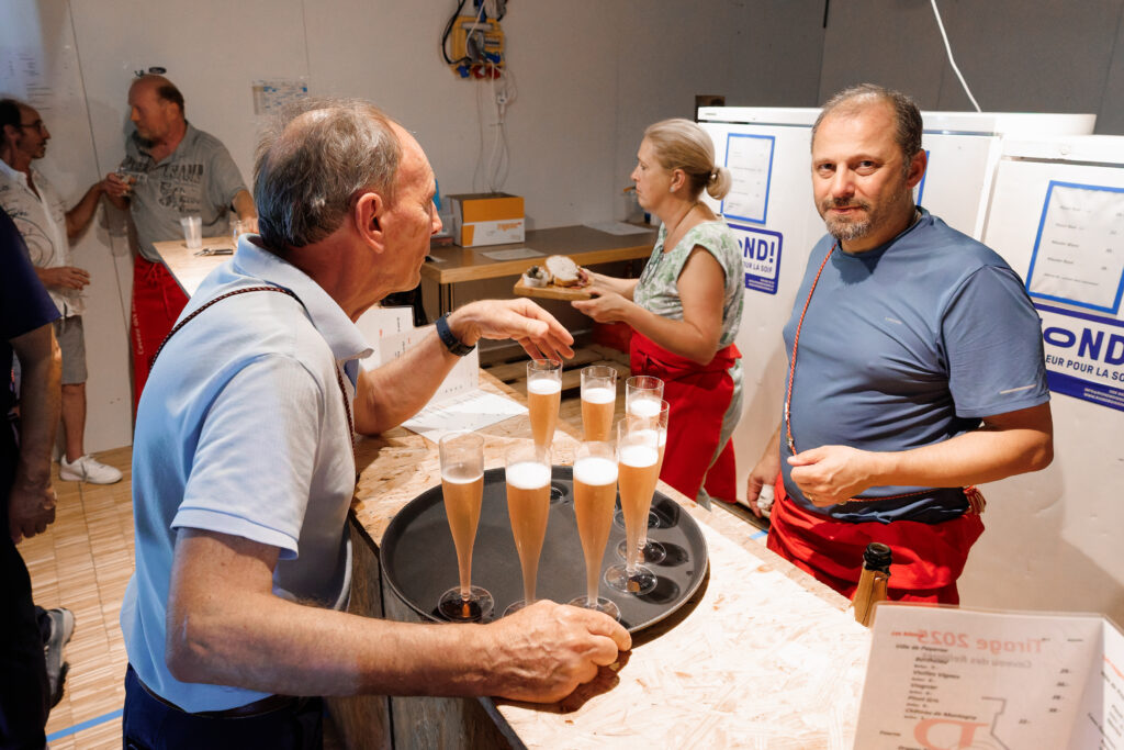 Deux hommes conversant autour de flûtes de champagne rosé
