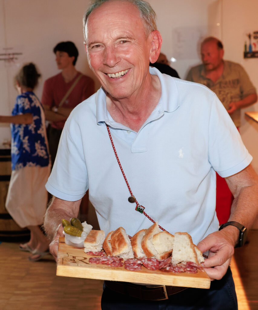Homme souriant tenant une planche de charcuterie et pain
