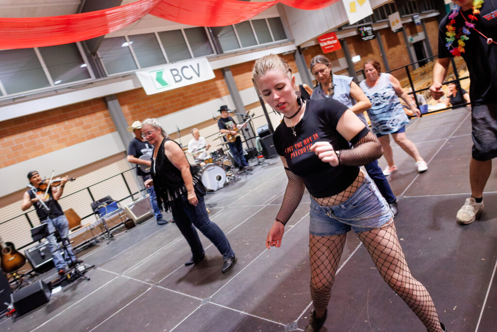 Femme dansant en tenue rock lors d'un festival avec musiciens