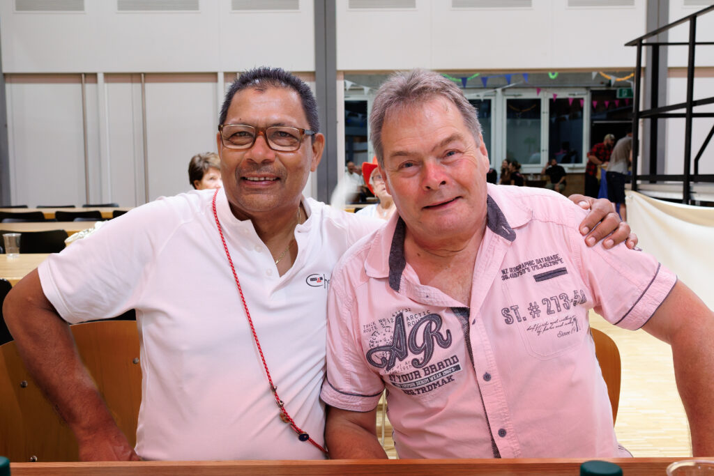 Deux hommes souriants posant ensemble lors d'un événement