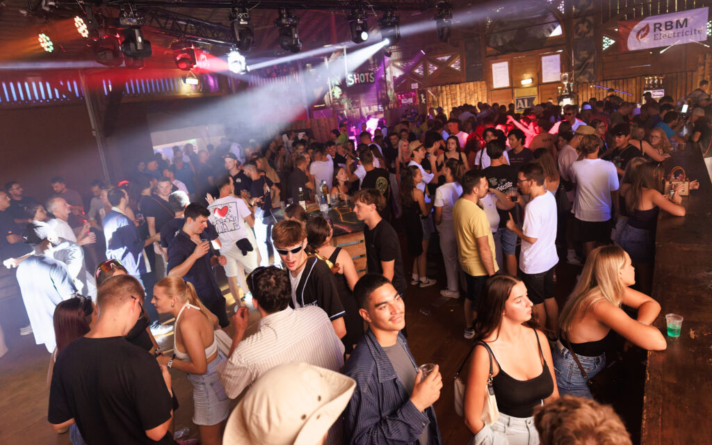 Foule de jeunes festivaliers dans une discothèque avec jeux de lumières
