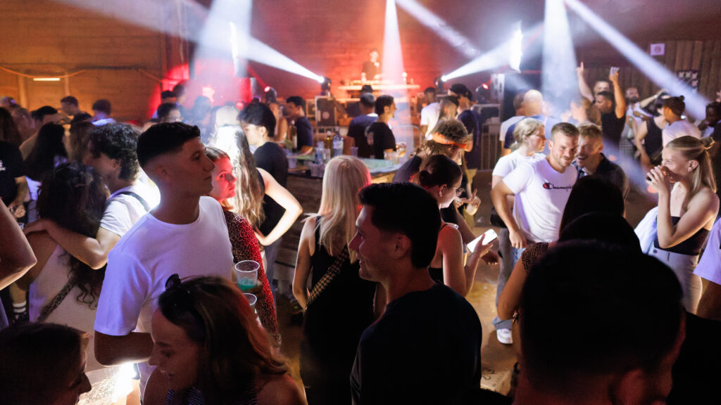 Foule de jeunes dansant en soirée avec jeux de lumières