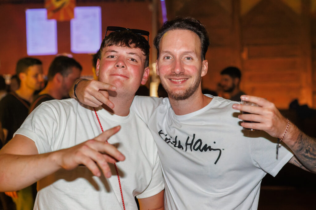 Deux hommes souriants en t-shirts blancs lors d'une soirée