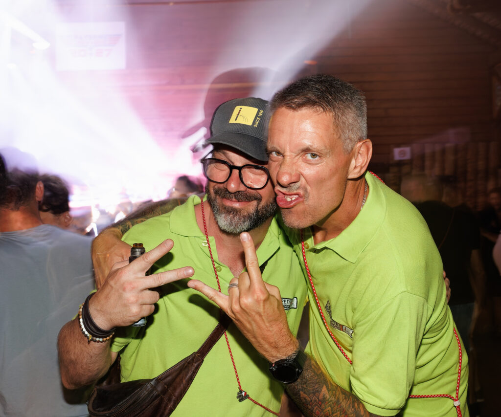 Deux hommes en polo vert fluo faisant des grimaces en soirée