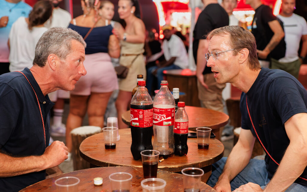 Deux hommes en conversation autour d'une table avec des Coca-Cola