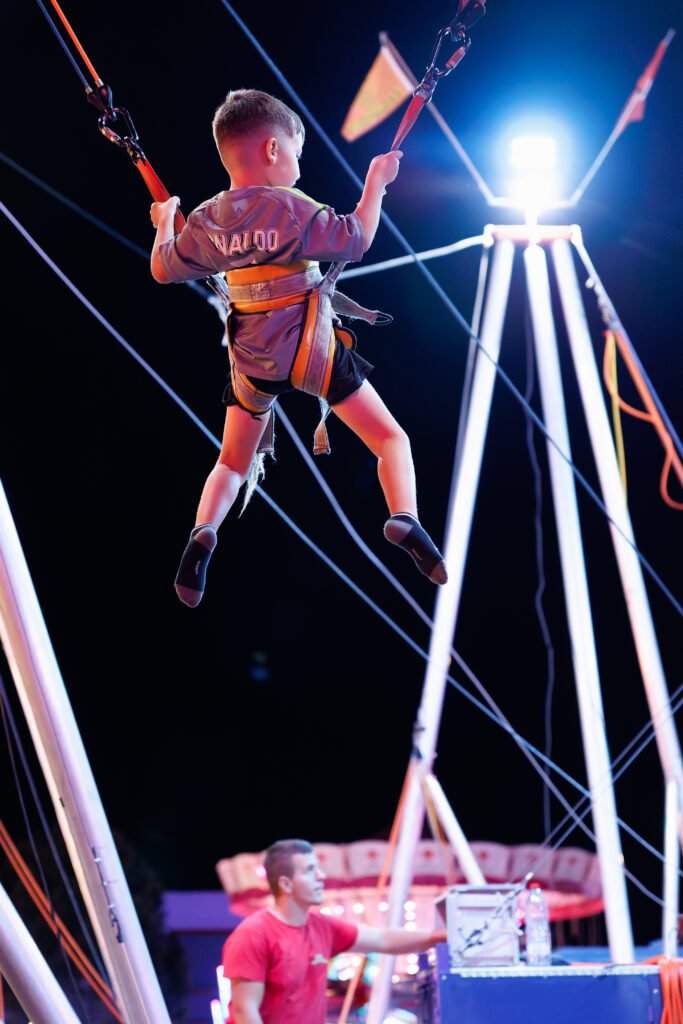Enfant suspendu en hauteur sur trampoline élastique de fête foraine